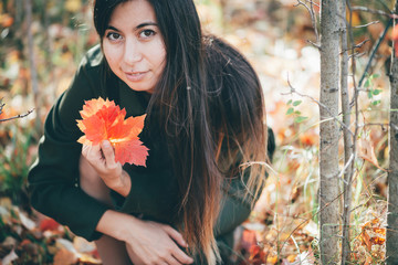 Female beauty portrait surrounded by vivid foliage. Dreamy beautiful girl with long natural black...