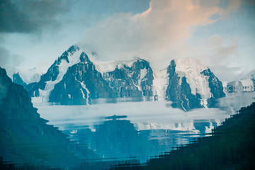 Huge glacier reflected in water surface. Water reflection of giant snowy rocky mountains under cloudy sky. Thick fog in mountains. Atmospheric landscape. Tranquil reflection in mountain lake.