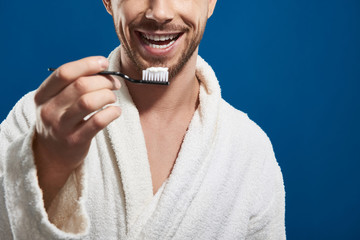 Close up of Caucasian young man posing for camera against blue background