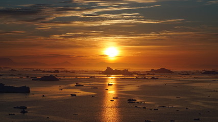 Sunset on icebergs in Arctic Ocean