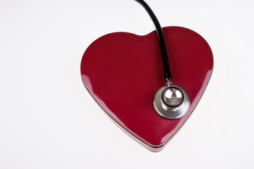 Stethoscope on a big dark red heart. Listen to heartbeat