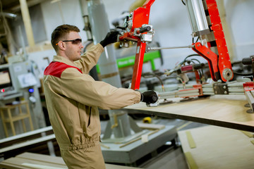 Young man working in the furniture factory