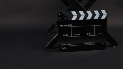 Fototapeta na wymiar Black Clapperboard or clap board or movie slate with director chair use in video production ,film, cinema industry on black background.