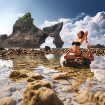 Beautiful young woman practice yoga on the paradise beach