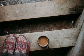 coffee mug on a wooden beam and warm socks