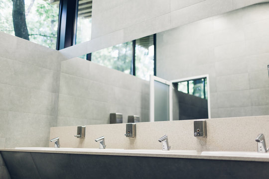 Modern Interior Design In Public Toilet. New Sinks, Taps With Mirror And Window Above