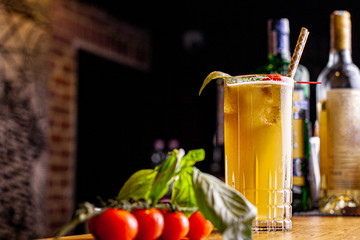 Alcoholic cocktail Basil smash with green basil, gin, sugar syrup, lemon juice and ice, black background, selective focus