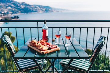 Two glasses of wine and italian snacks  with amazing view at sunset in Italy.