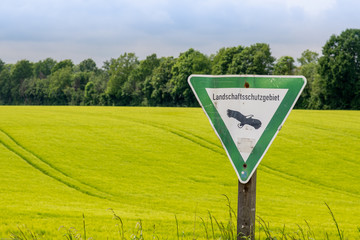 Hinweisschild vor einem Feld