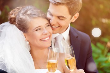 Young Wedding Couple Bride and Groom holding champagne glasses