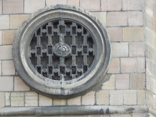 Fragment of a building wall with an architectural ornament in the form of a metal patterned circle