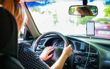 girl in the car holds the steering wheel and toot