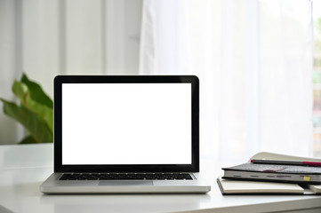 Fototapeta premium Laptop empty screen on white table with notebook paper.