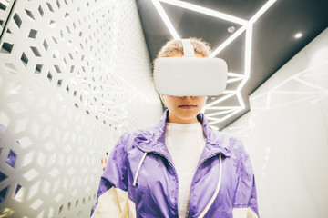 Portrait of girl wearing virtual reality headset. Creative young girl in futuristic room.