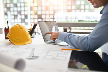 Architect man working on blueprint with engineer planing on office desk.