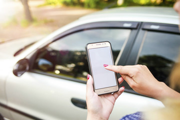 girl holding a phone in the background of the car. Theme car rental using phone car sharing.