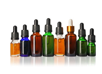 Cosmetic bottles of essential oils on white background