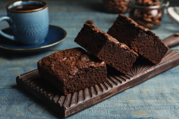 Wooden board with fresh brownies on table. Delicious chocolate pie