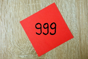 Emergency number 999 written on a red sticker