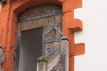 Medieval wooden door of a castle with red decorations (Germany, Europe)