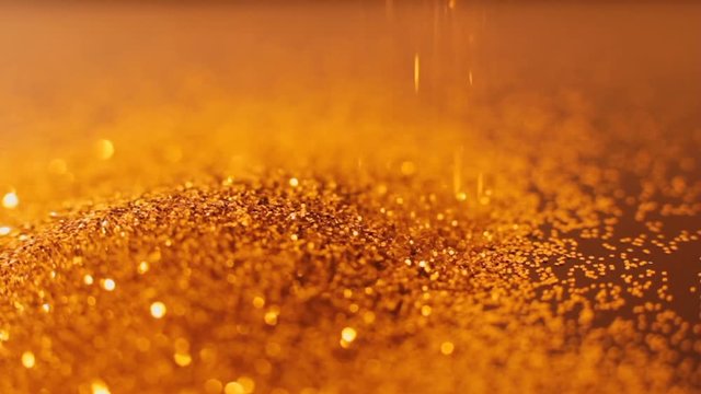Gold glitter sprinking down. Shiny glistening defocused particles motion