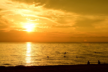 Obraz premium The rising sun and the golden yellow sky at the beach by the sea in the early morning
