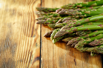 Fresh green asparagus on yellow wooden table 
