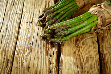 Fresh green asparagus on yellow wooden table 