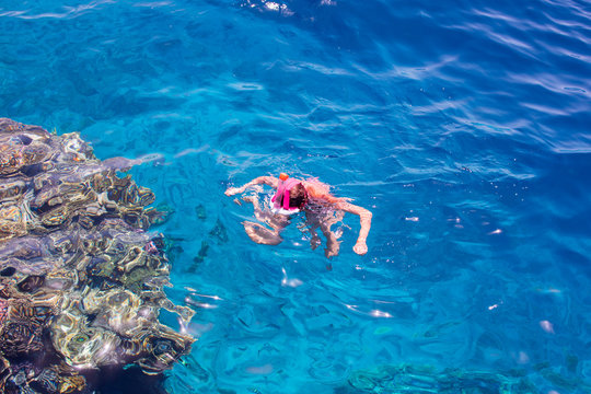 Snorkeling gear.  Snorkeling girl in  full face mask. Underwater swimming in Red sea near a coral reef. Tropical vacation activity snorkeling