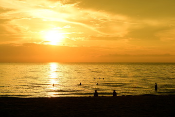 The rising sun and the golden yellow sky at the beach by the sea in the early morning