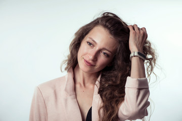 pretty stylish young girl model with long curly hair in a jacket on a white background