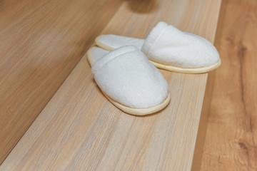 Hotel complex. White disposable Slippers on the floor. Office for Spa treatments. Bathroom.