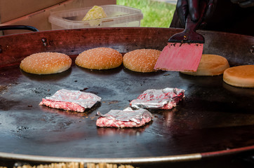street food, hamburgers and meat patties in a large frying pan