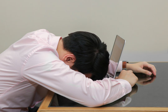 stressed businessman sleep on his laptop with burnout syndrome