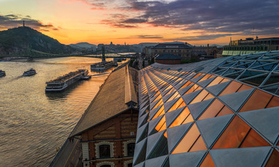 Naklejka premium Budapest, Hungary - Panoramic view of a beautiful sunset over River Danube with Liberty Bridge, Gellert Hill and Buda Castle Royal Palace at background
