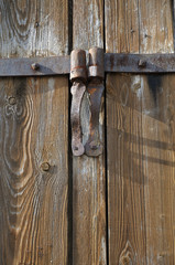 rusty iron hinges at old wooden barn door