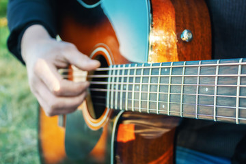 Play the Guitar. Stretched guitar strings. Musical art. Outdoor recreation