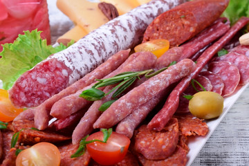 Smoked sausages assortment on the white tray. Meat plate