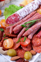 Smoked sausages assortment on the white tray. Meat plate