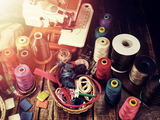 Sewing accessories group object sewing spool and serger top view. Beam shines through window.