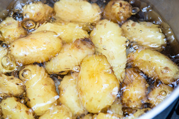 Jersey royal potatoes cooking in boiling water in a large saucepan