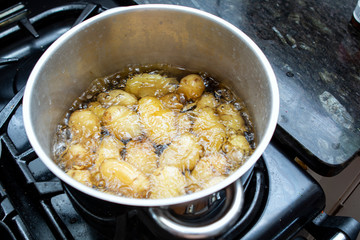 Jersey royal potatoes cooking in boiling water in a large saucepan
