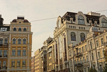 Fototapeta na wymiar brown high apartment buildings on a city street against the sky