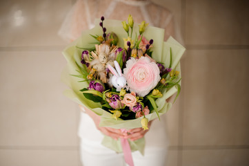 woman holding a bouquet of tender pink and violet spring flowers