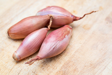 echalion banana shallots on a wooden chopping board