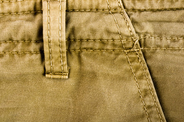 clothing items stonewashed cotton fabric texture with seams, clasps, buttons and rivets, macro