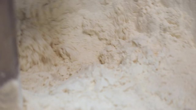 Industrial factory, machinery for mixing dough, food concept. Stock footage. Close up for kneading dough at the bakery, confectionery, equipment for making flour products.