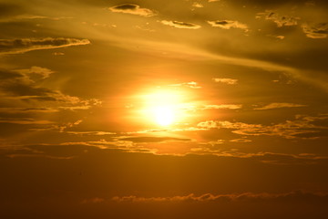 The rising sun and the golden yellow sky at the beach by the sea in the early morning