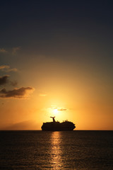 Obraz premium a cruise ship sails along the horizon at sunset