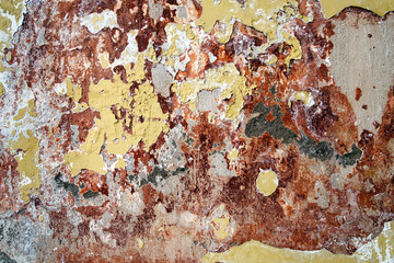 old painted cracked of cement background with yellow paint and red stains
